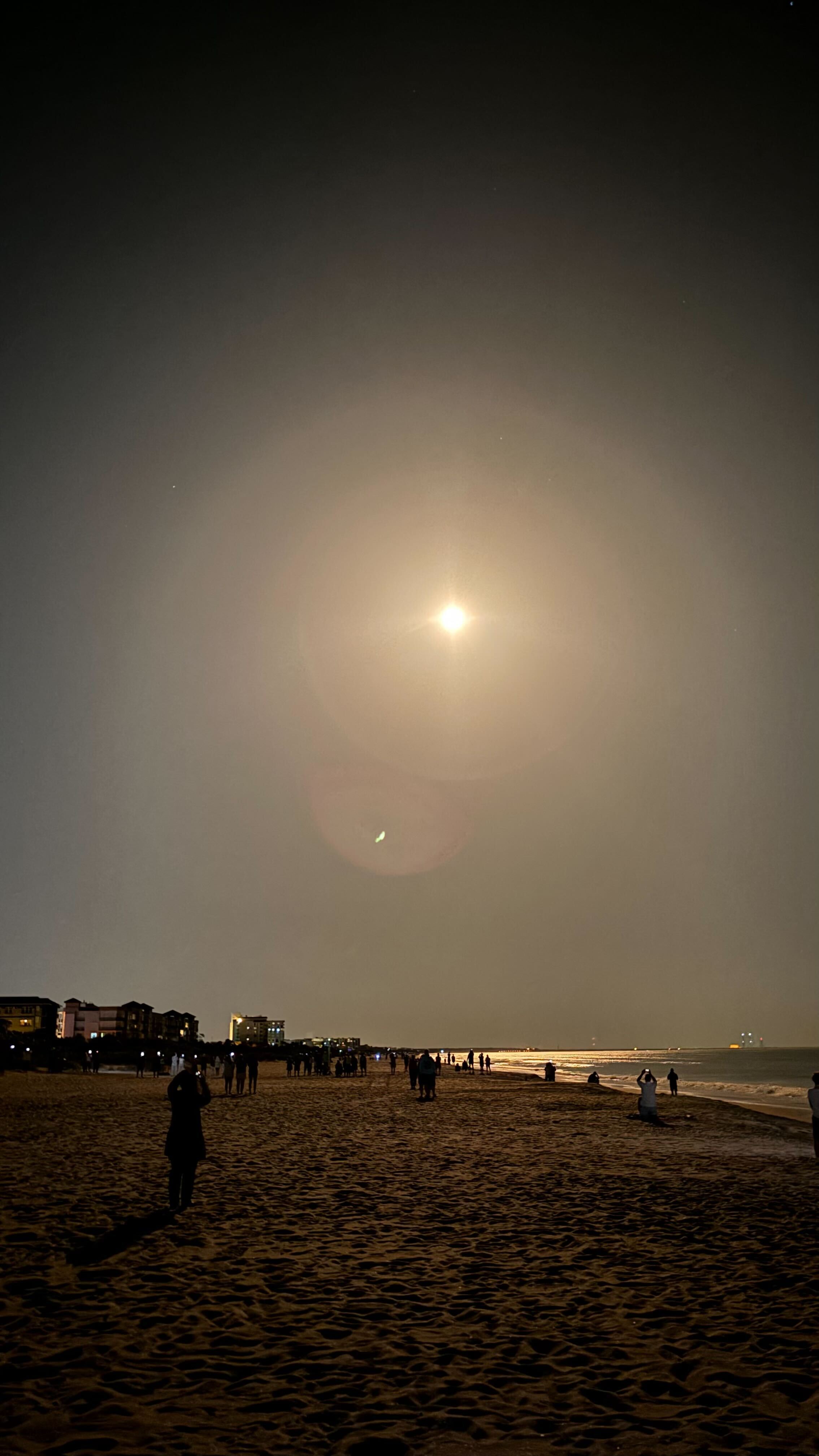 A rocket launching from Kennedy Space Center crossing the night sky, seen from Cocoa Beach